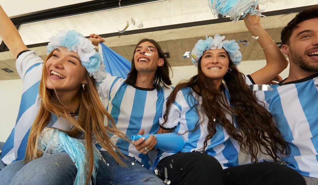 Soccer fans in blue and white striped jerseys cheering in a stadium